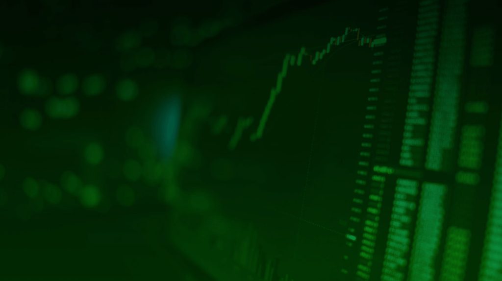 Green image of stock market data on screen